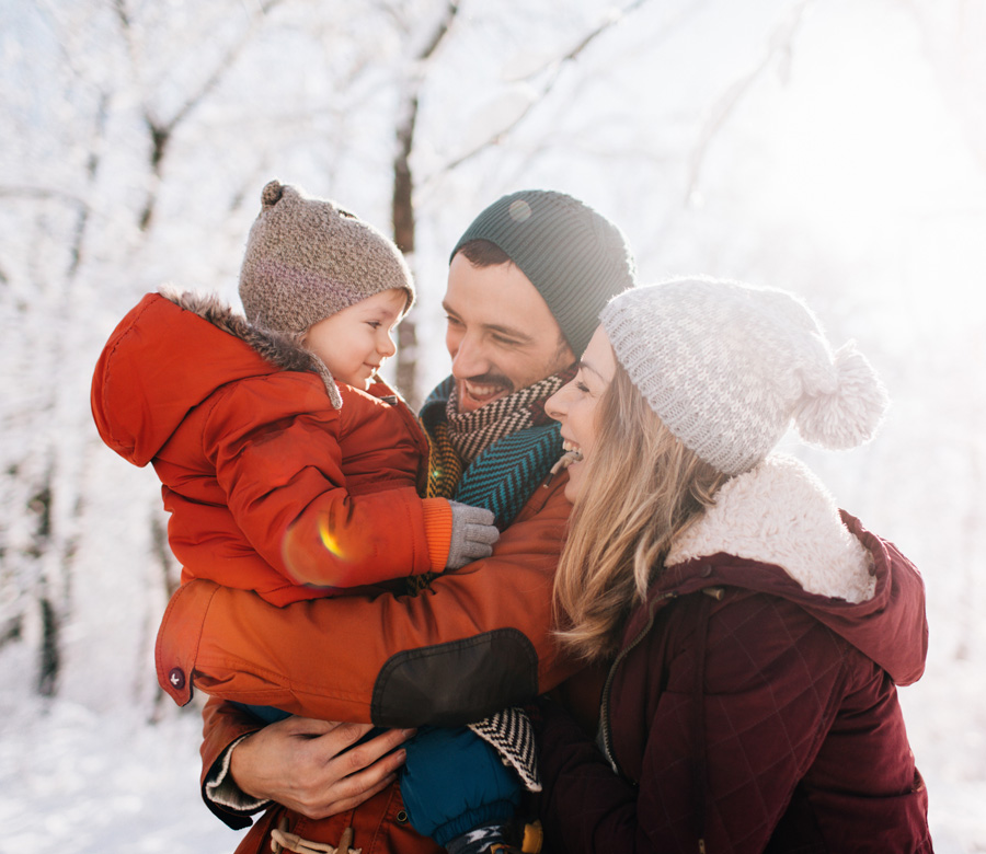 Family smiles together in the snow