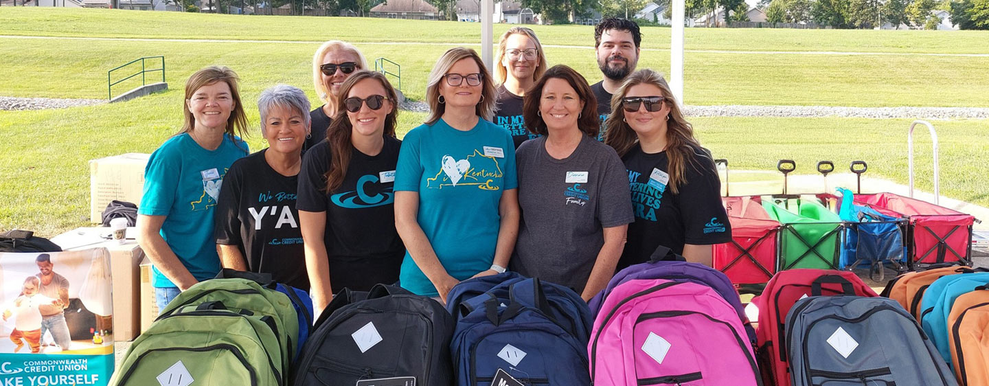 Image of CCU team members in front of a table full of backpacks.