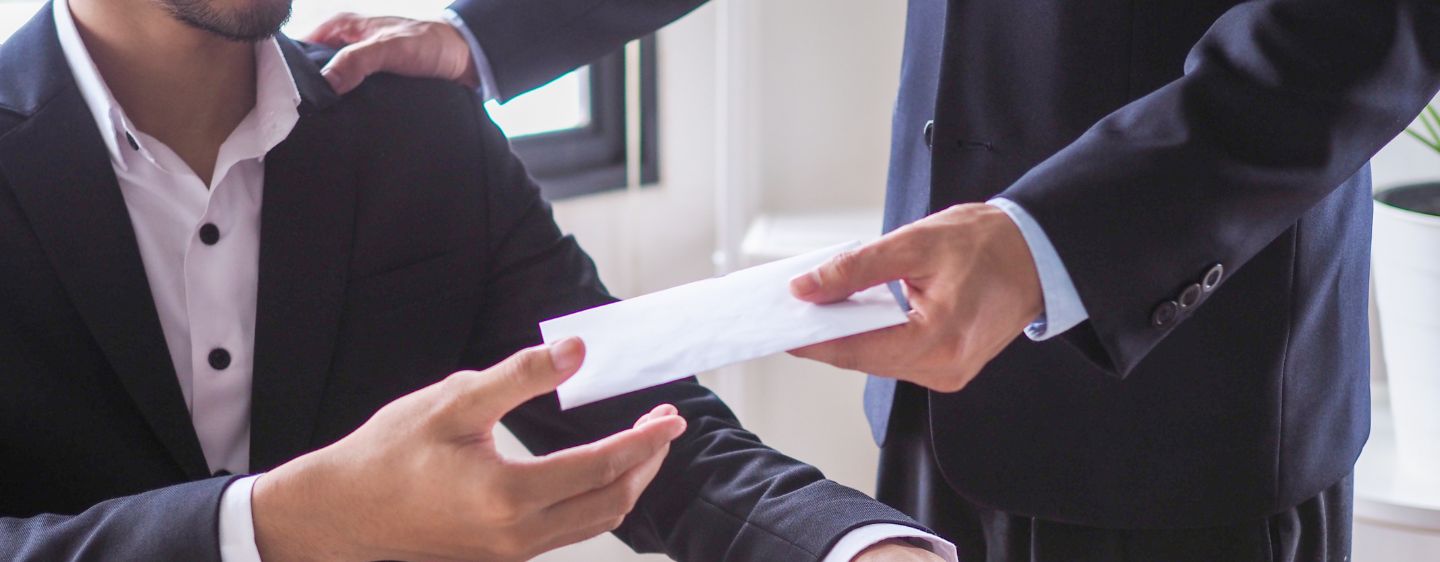 Man handing employee envelope.