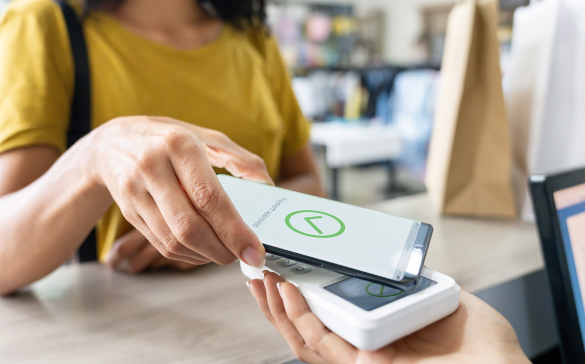 Woman using her phone to pay for a purchase.