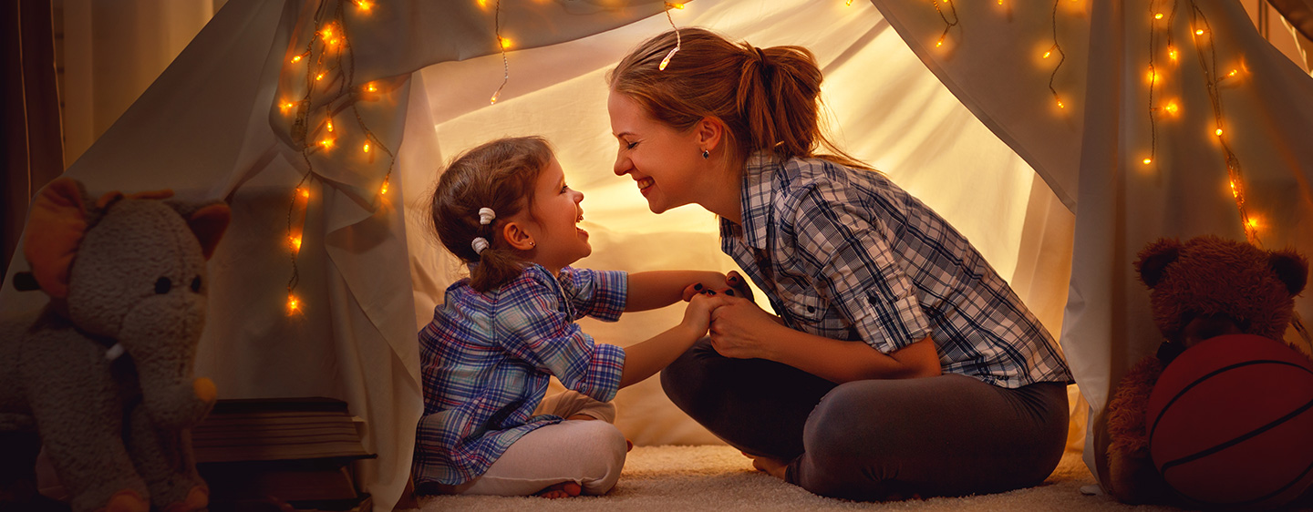 Mom and daughter playing in a tent.