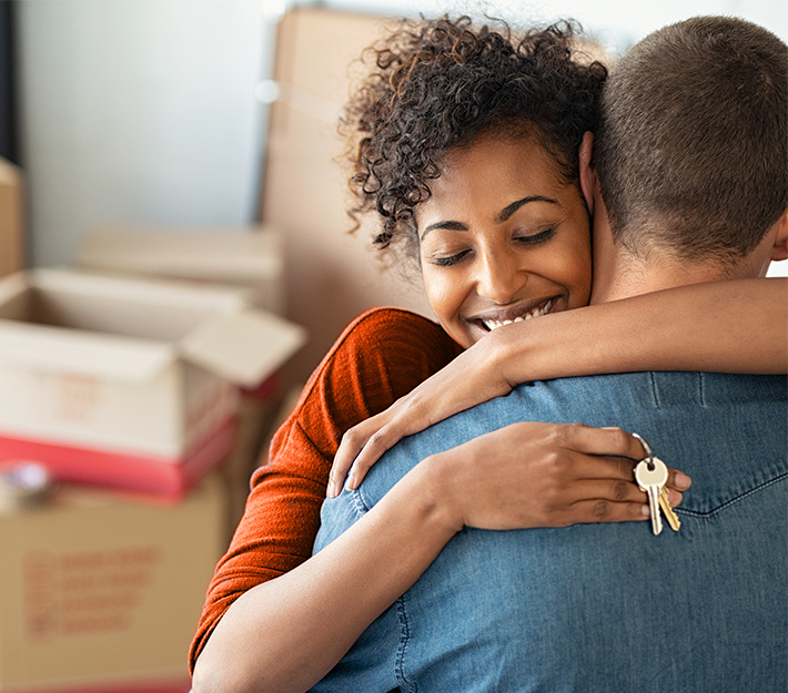 Woman hugging partner in new home.