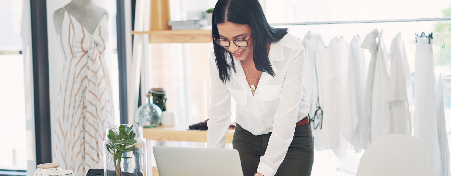 Image of woman working at her desk in her clothing shop.