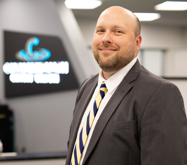 Image of CCU team member in front of a CCU logo