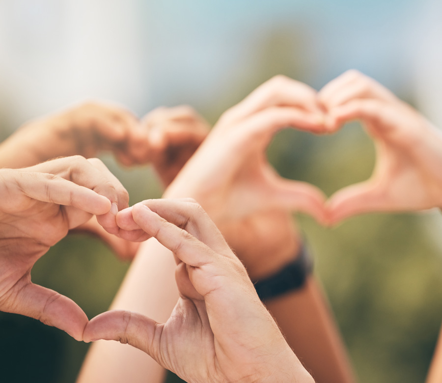 Image of people holding up their hands in a heart shape