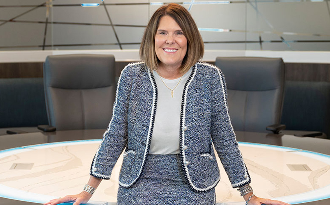 Image of Karen Harbin standing at a desk, smiling.