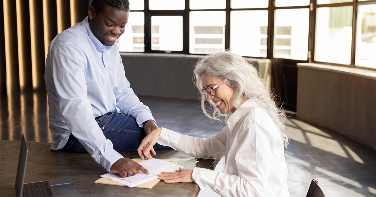 A younger man and older woman review her will together.