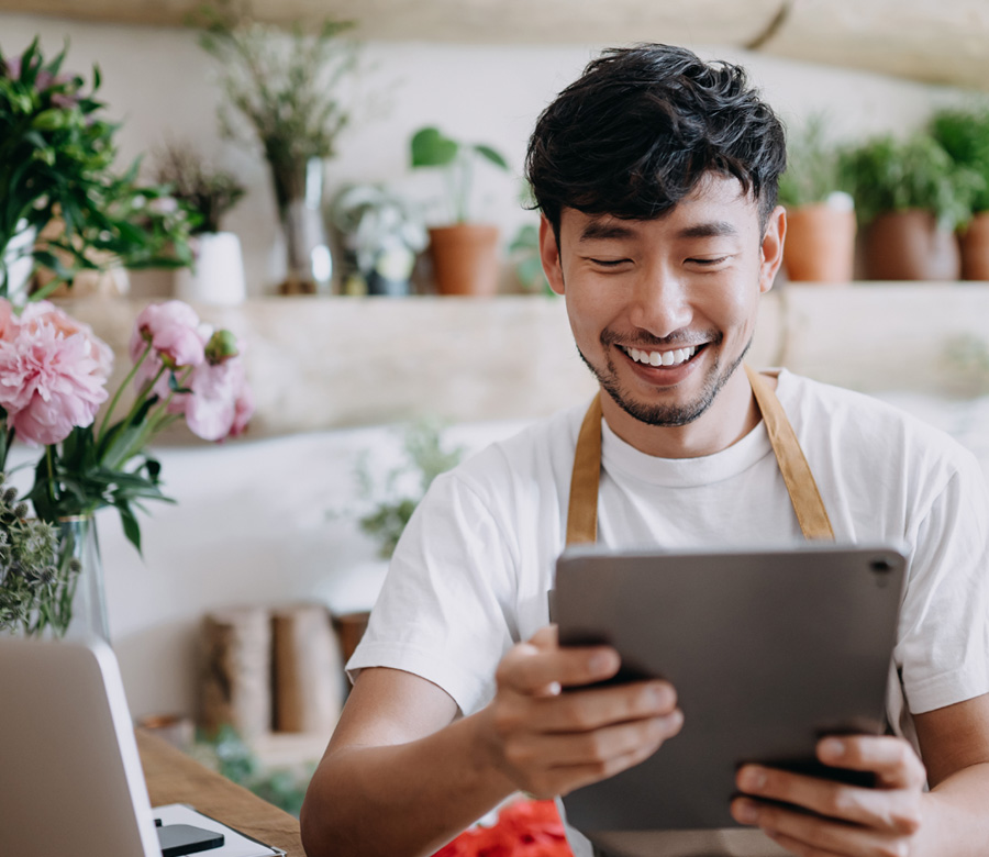 Business owner smiles at his tablet.