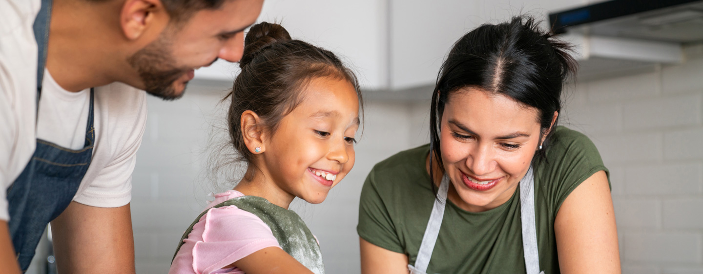 Image of parents and daughter making cookies together.