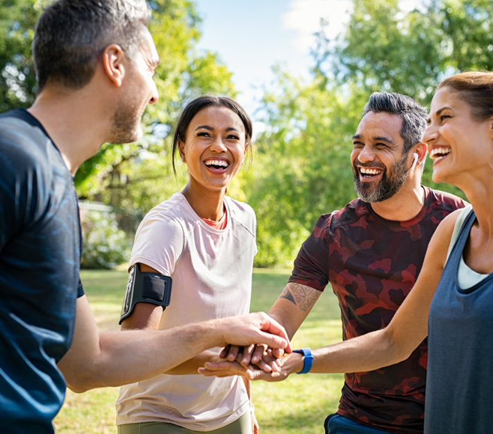 A group of friends stack hands after a workout